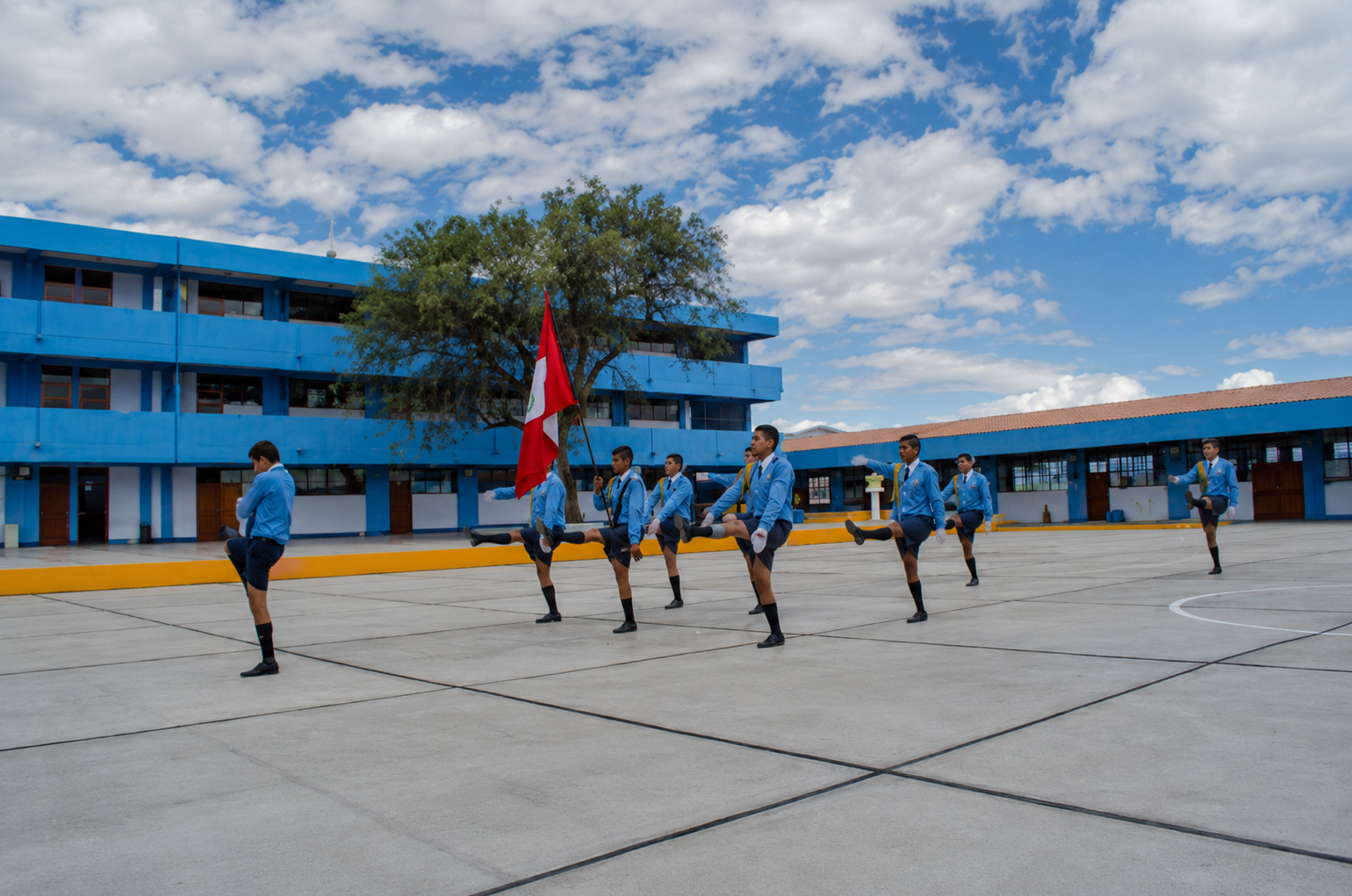 Estudiantes participando en ceremonia cívica en el patio institucional